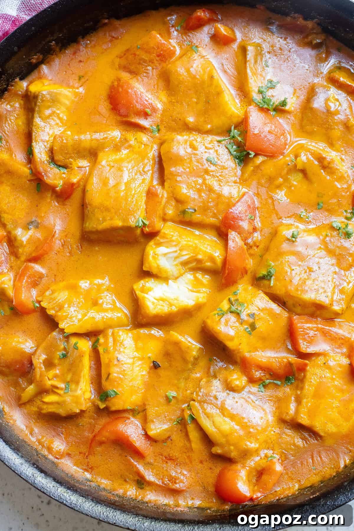 Close-up view of the fragrant Coconut Fish Curry in a pan, showcasing the rich sauce and tender fish.