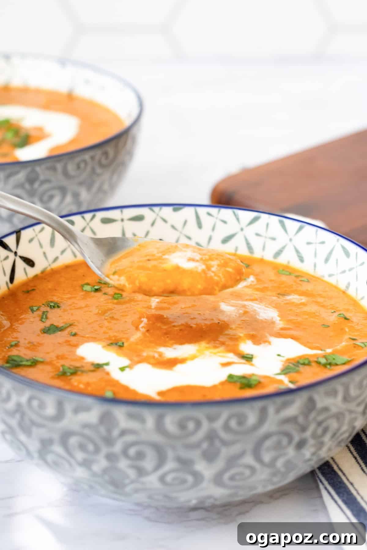 Comforting Lentil Tomato Soup 2 A bowl of Lentil Tomato Soup with a spoon, garnished with fresh herbs, ready to be enjoyed.