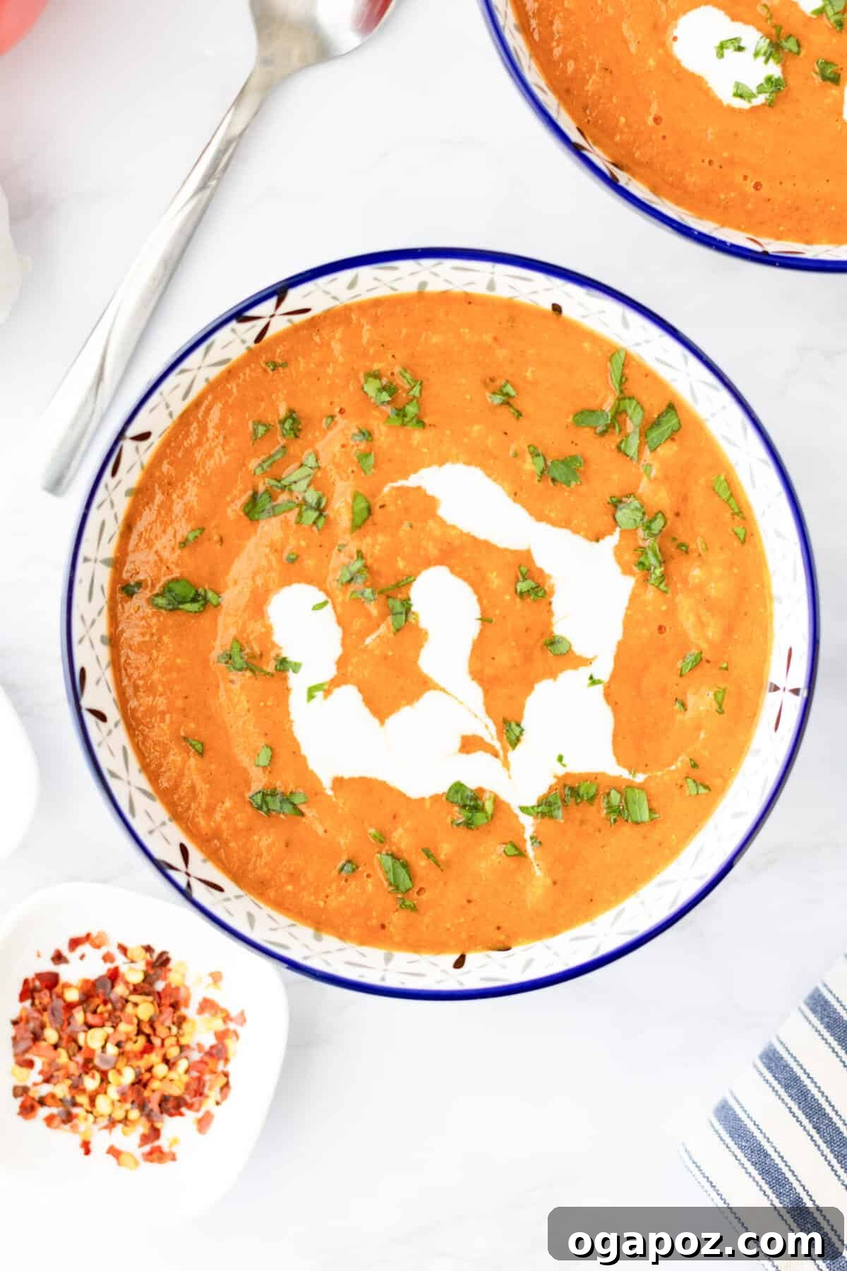 Comforting Lentil Tomato Soup 7 Lentil Tomato Soup garnished with a swirl of Greek yogurt and fresh herbs.