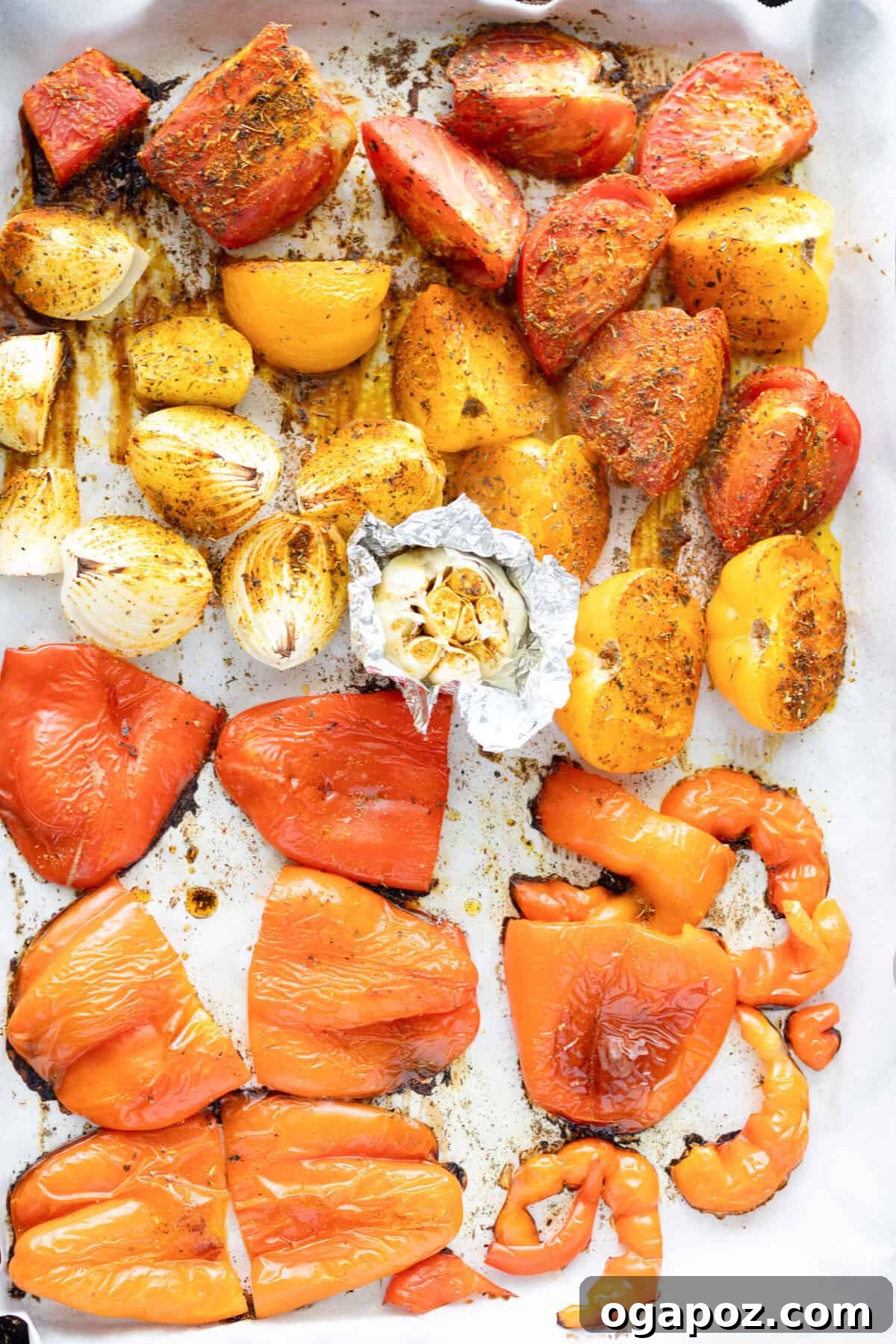 Comforting Lentil Tomato Soup 8 Lentil Tomato Soup ingredients roasting on a baking sheet, showing charred bell pepper skin.