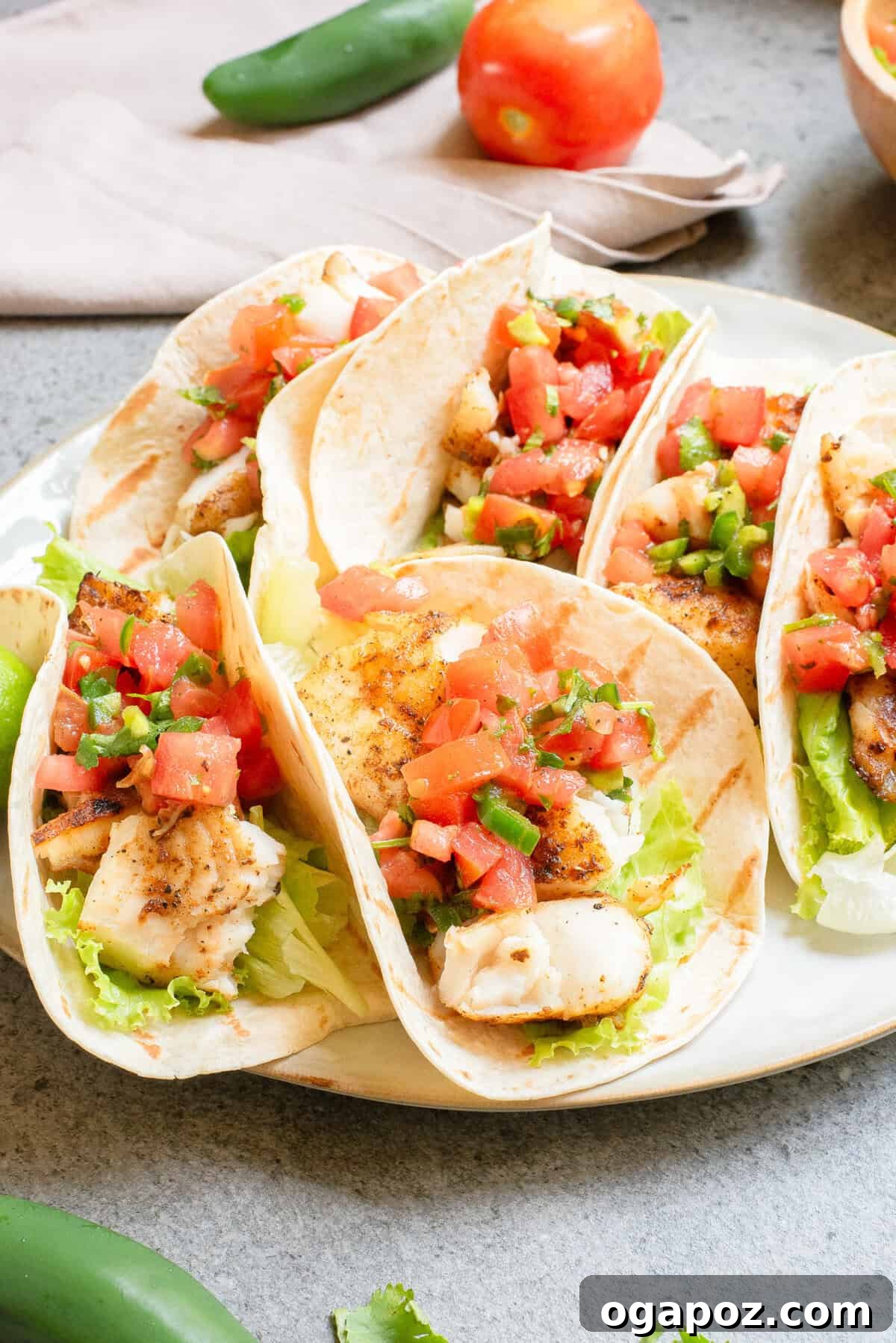Fiery Fish Tacos 2 Blackened Fish Tacos on a plate with fresh salsa and lime wedges