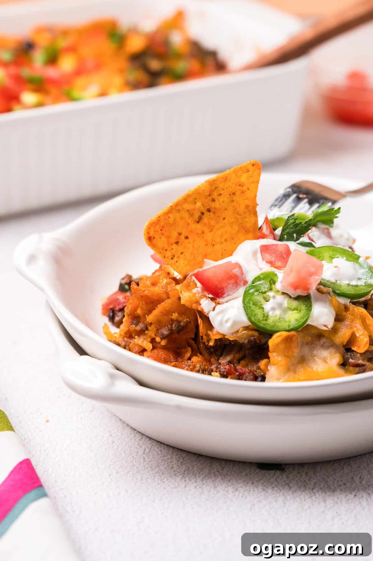 A serving of Doritos Taco Casserole in a bowl, showing the layers