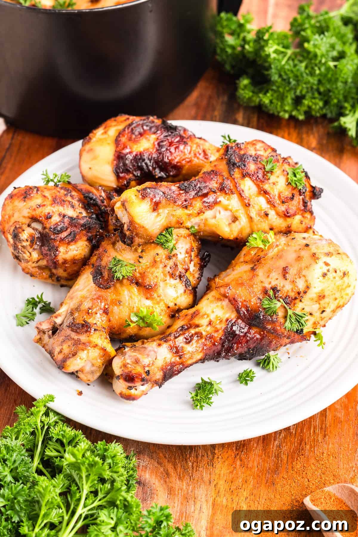 Extra Crispy Air Fried Drumsticks 2 Crispy Air Fryer Chicken Legs on a white plate with fresh parsley garnish