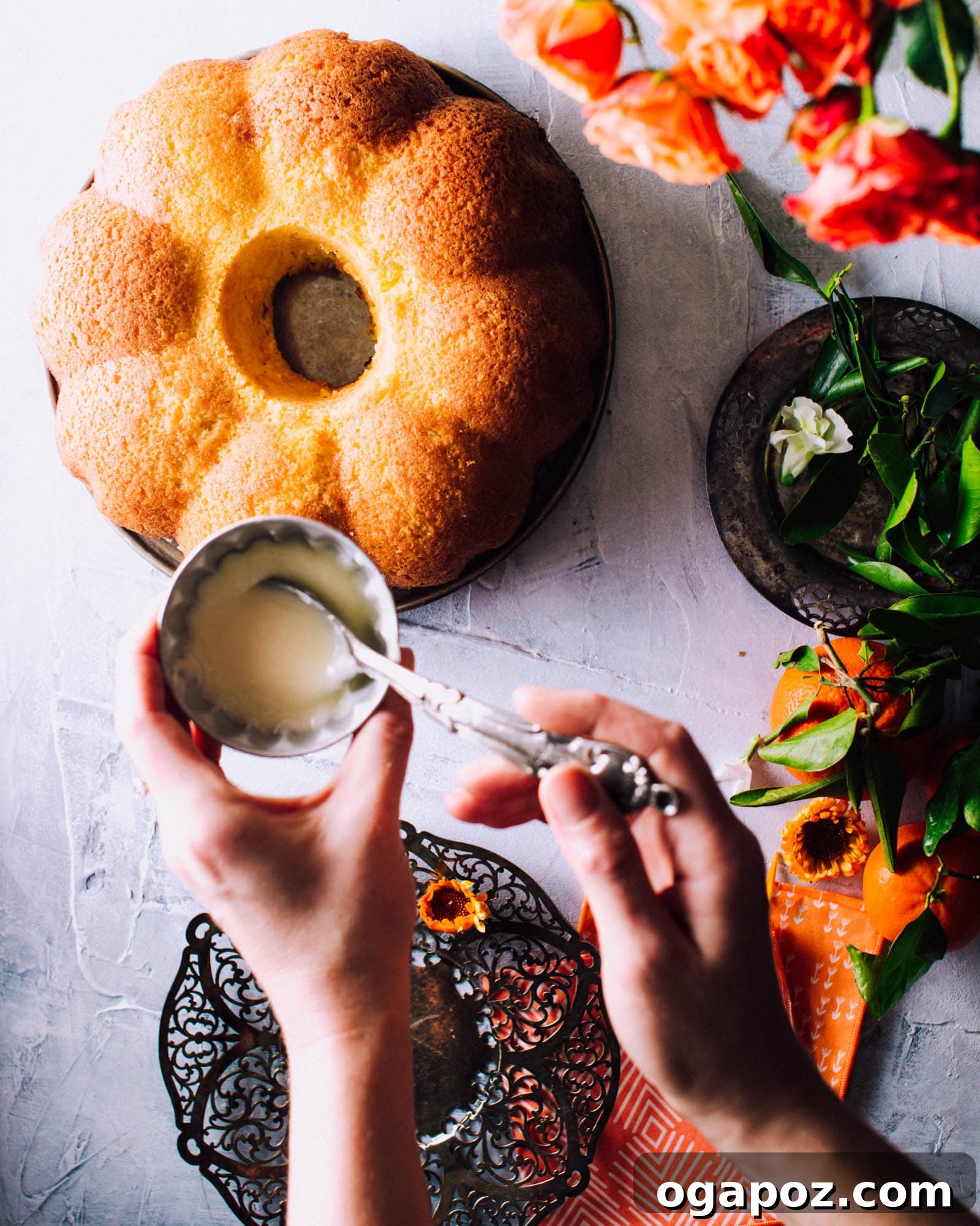 Close-up of a beautifully sliced orange pound cake adorned with fresh flowers, showcasing its tender, moist crumb and orange glaze