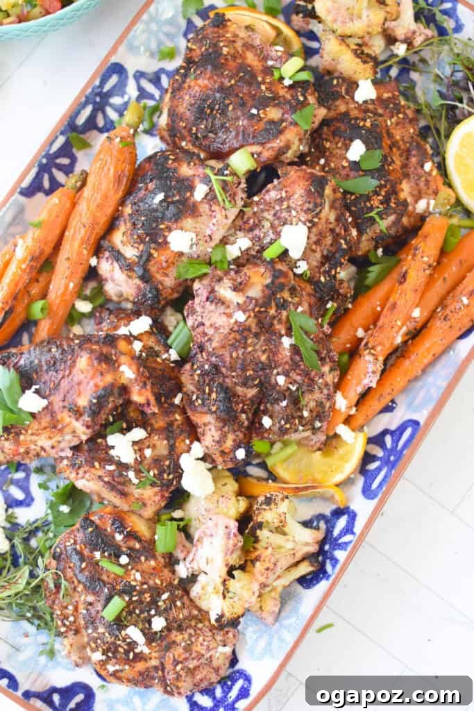 One Pan Roasted Zaatar Chicken 9 The finished Sheet Pan Za'atar Chicken arranged on a white and blue platter, garnished with fresh herbs.