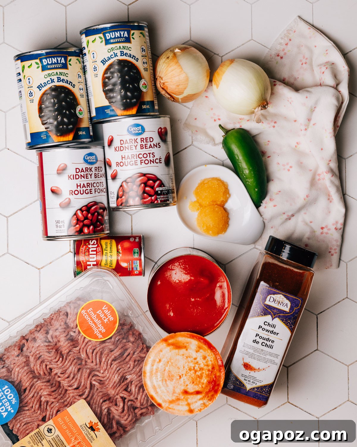 Rich and Flavorful Chili Con Carne 3 Fresh ingredients laid out for making chili con carne, including a variety of spices, ground beef, tomatoes, and vibrant green jalapeños.