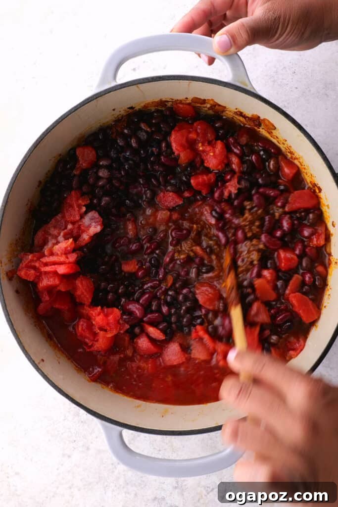 Rich and Flavorful Chili Con Carne 7 Step 4: Stirring rich tomato paste into the browned ground beef and spices, allowing it to toast and darken.
