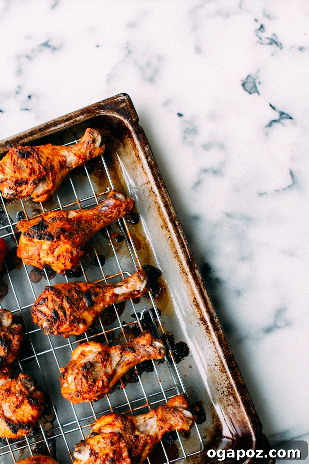 Succulent Baked Tandoori Chicken 4 Oven-baked Tandoori Chicken drumsticks with a golden-brown, charred crust, served with lemon wedges.