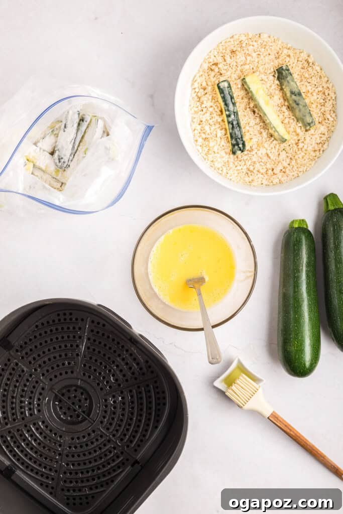 Zucchini sticks being coated in breadcrumbs