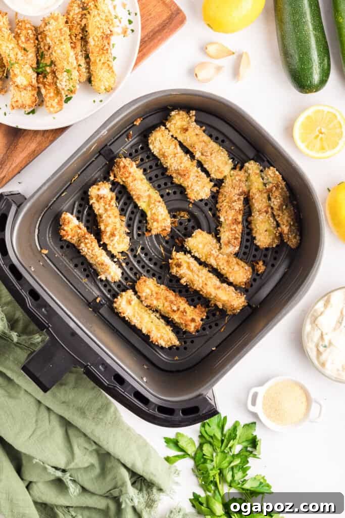 Crispy zucchini fries cooking in an air fryer basket
