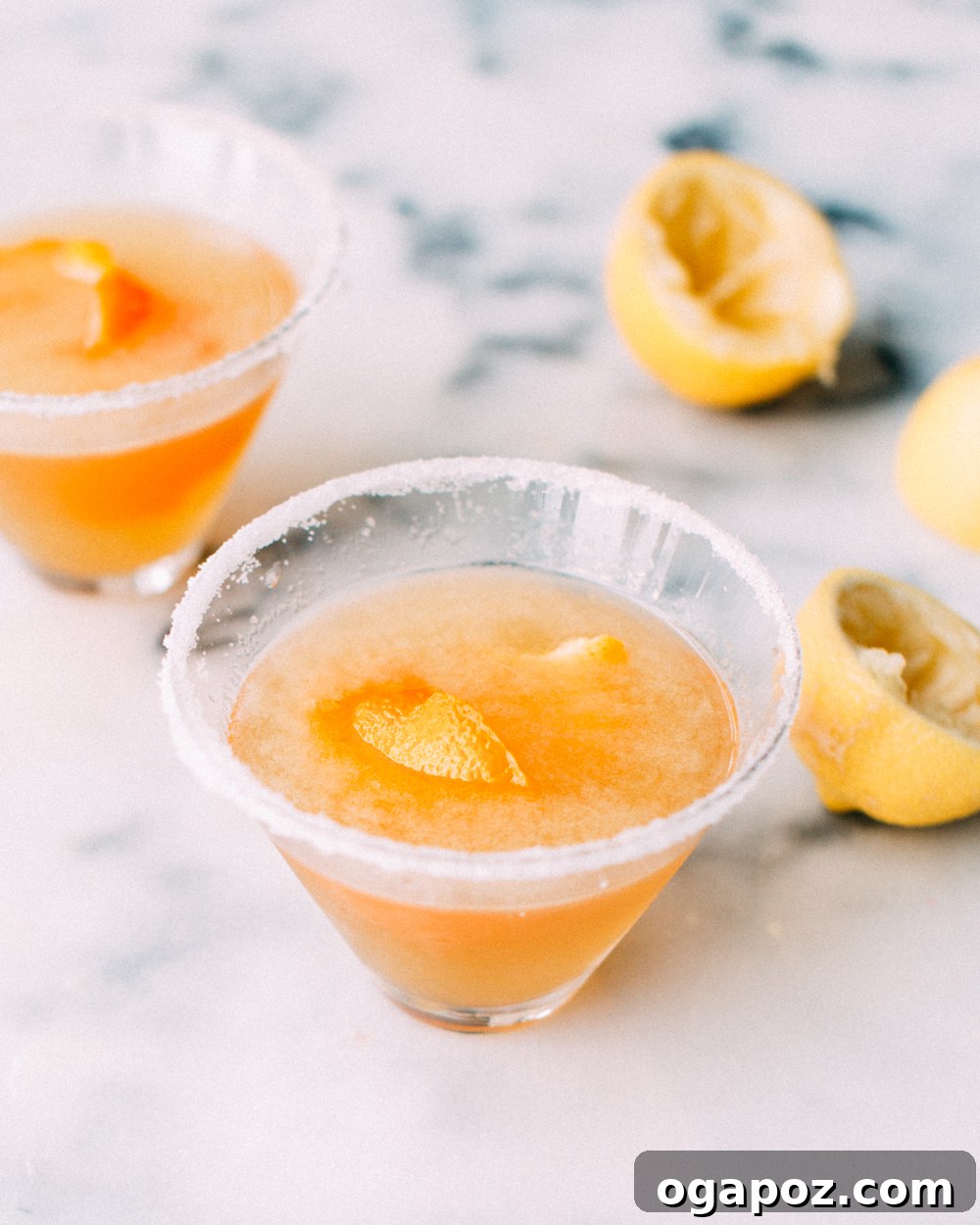 Sun Kissed Sidecar 2 A perfectly crafted Citrus Sidecar cocktail in a sugar-rimmed glass, garnished with an elegant orange twist, sitting gracefully on a wooden surface.