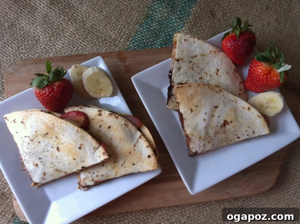 Heavenly Sweet Quesadillas 3 Two halves of a Dessert Quesadilla, garnished with fresh fruit, on a pristine white plate, ready to be enjoyed.
