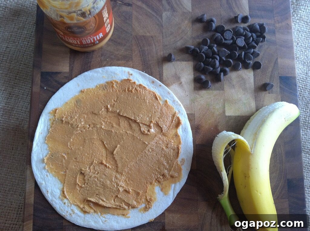 Heavenly Sweet Quesadillas 5 A flour tortilla spread with a thick layer of peanut butter on a cutting board, ready for fruit and chocolate.