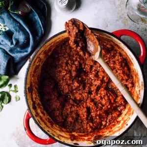 Effortlessly Decadent Meat Sauce 3 Meat Sauce in a pot with a spoon.