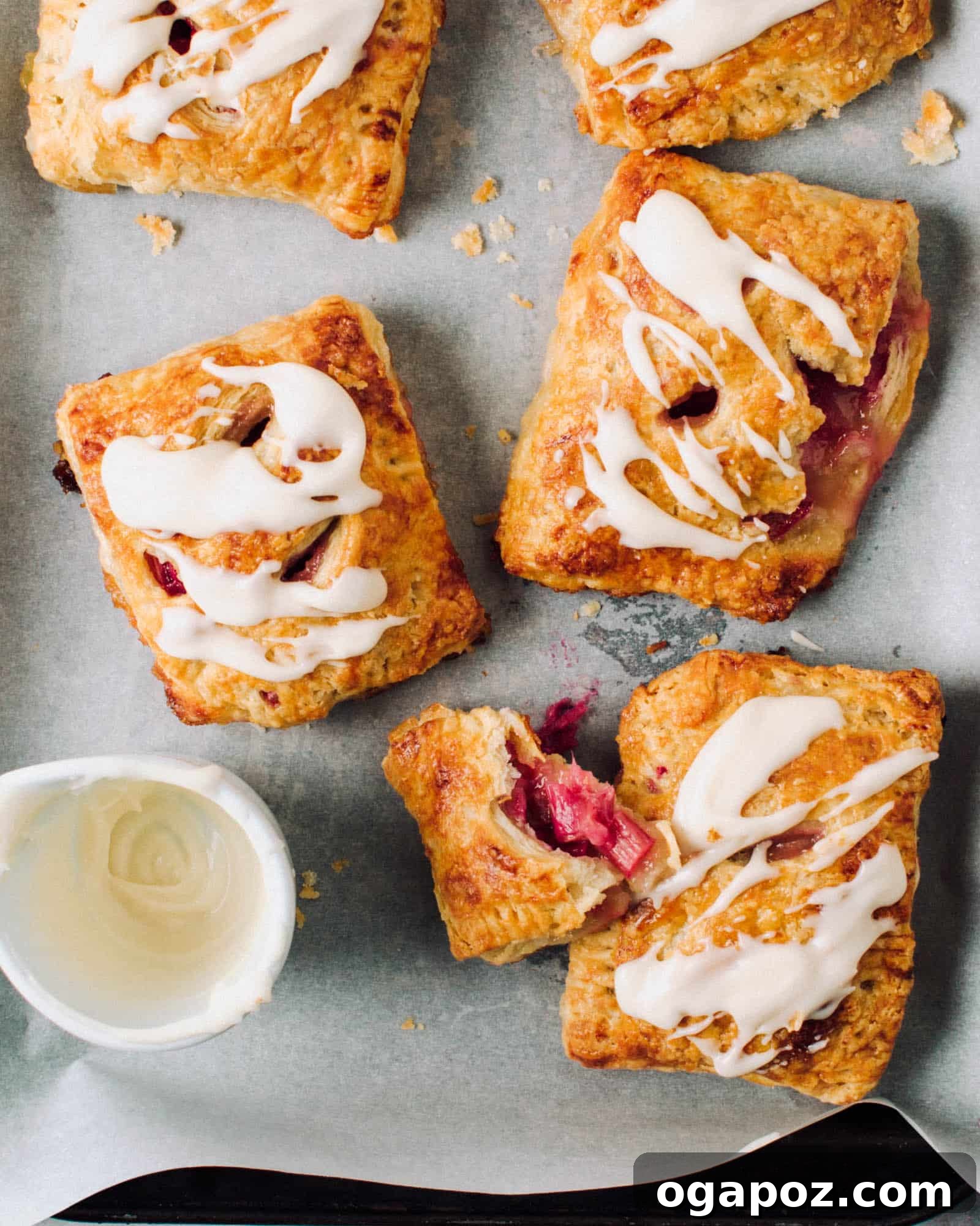 Baked Rhubarb Turnovers with Vanilla Glaze 2 Rhubarb hand pies with icing on a tray. Perfect homemade spring and summer dessert.