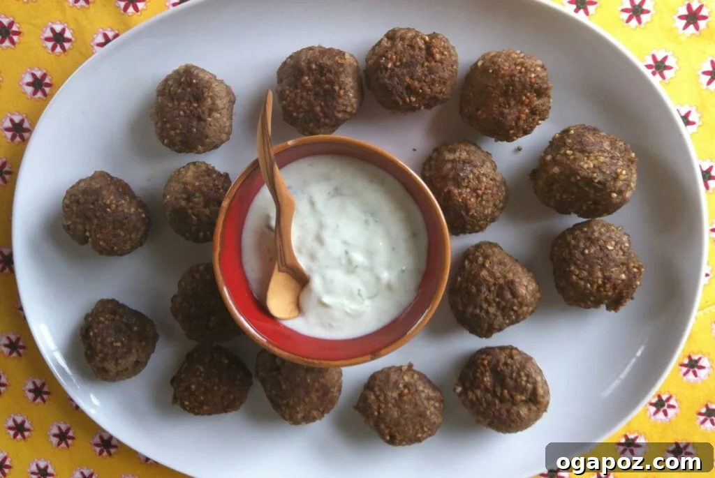 Savory Kibbeh with Tangy Spiced Yogurt 3 Plate of golden-brown Kibbeh Meatballs with a side of Spiced Yogurt Sauce