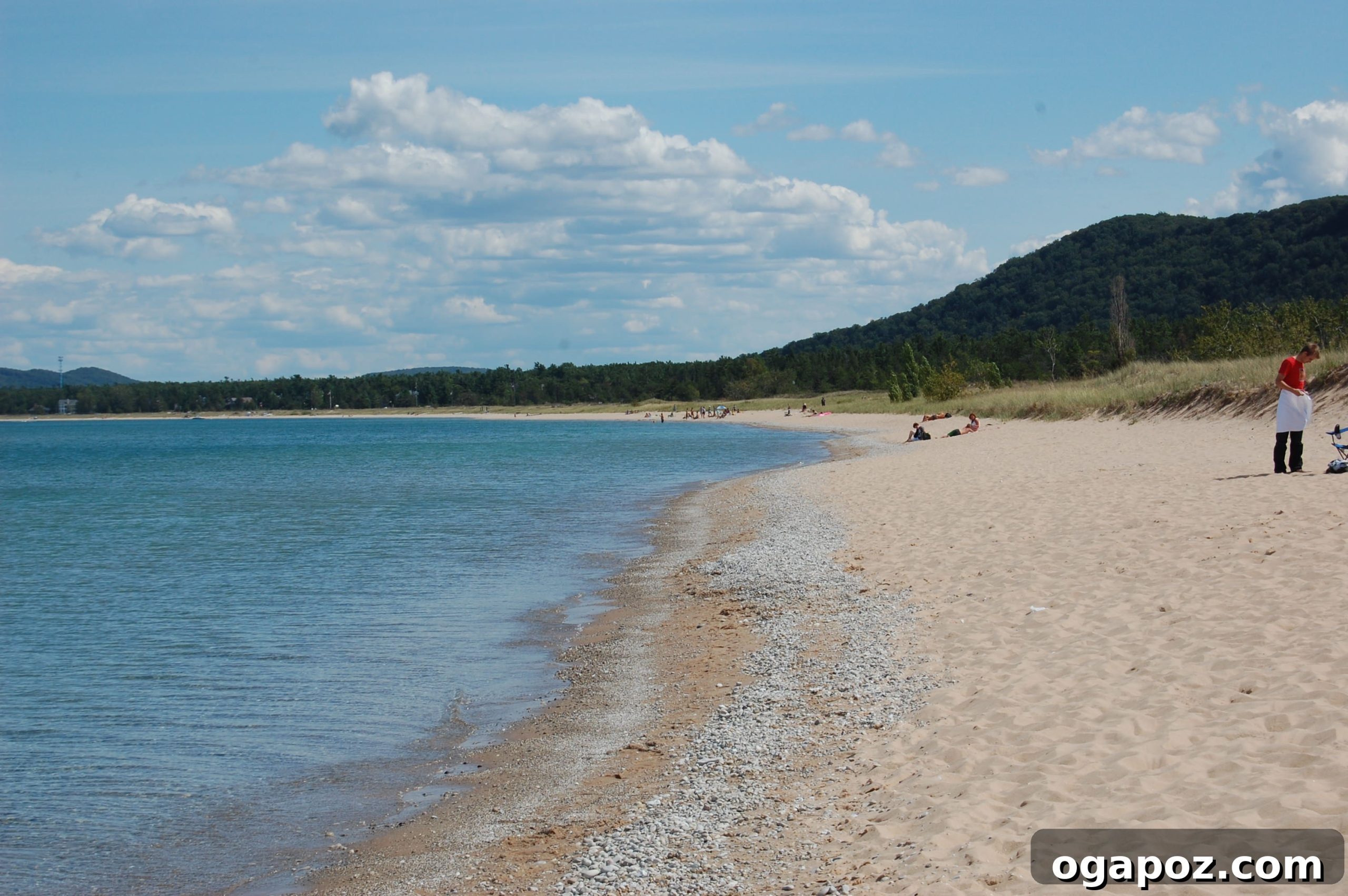Sleeping Bear Dunes Beach A serene beach scene at Sleeping Bear Dunes with incredibly clear, blue water and a pristine sandy shore.