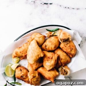 Chicken Samosas on a plate with one cut open.