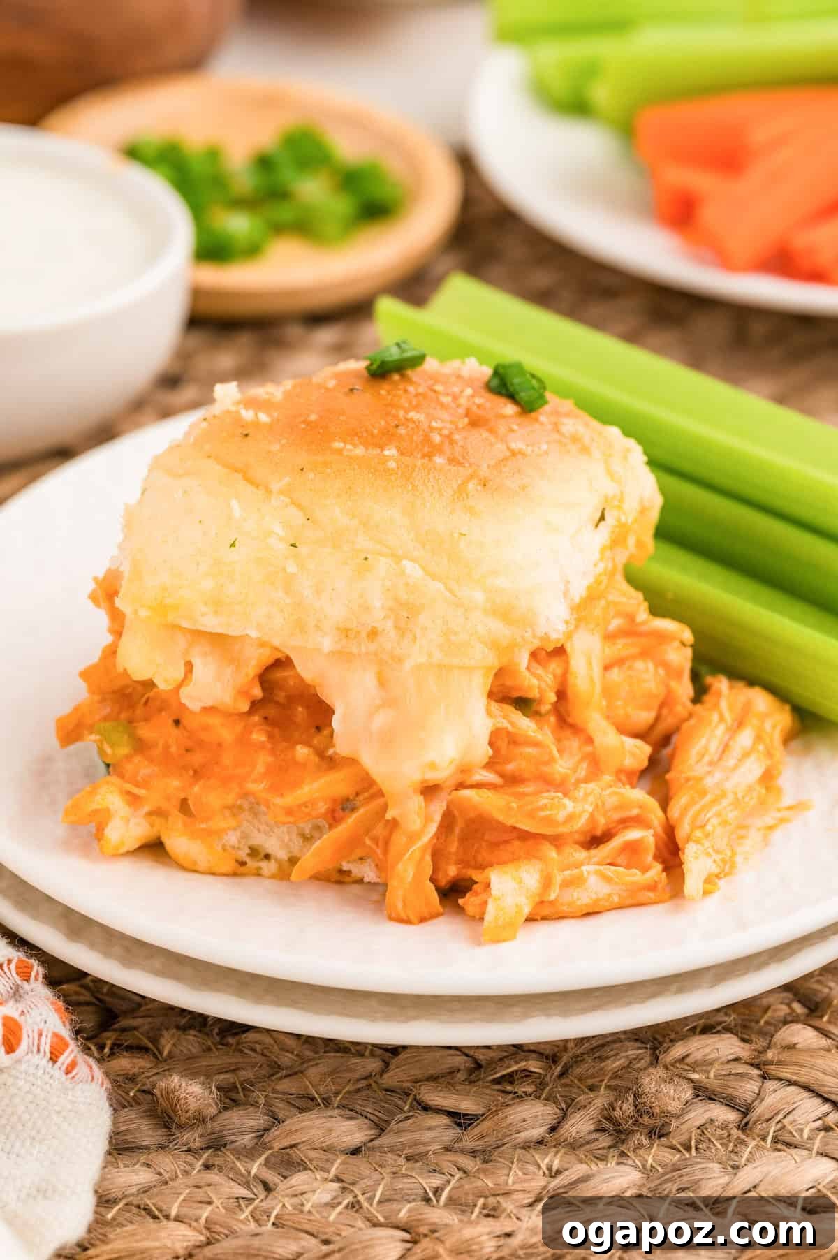 Ultimate Buffalo Chicken Sliders 5 Easy Buffalo Chicken Sliders on a white plate with celery sticks