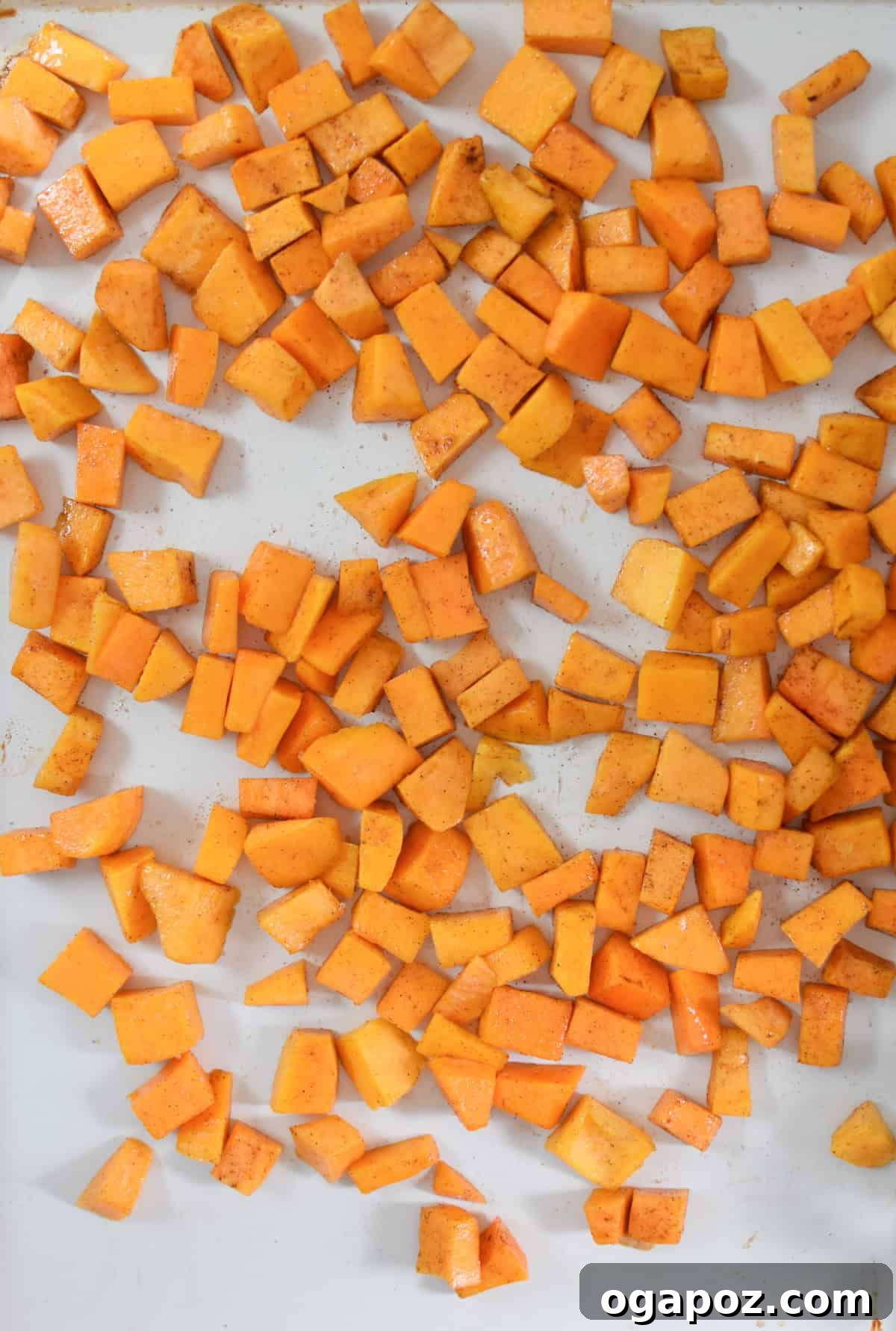 Autumn Harvest Orzo Pasta Salad 8 Cubed butternut squash seasoned with olive oil, salt, pepper, and cinnamon spread evenly on a baking sheet, ready for roasting.