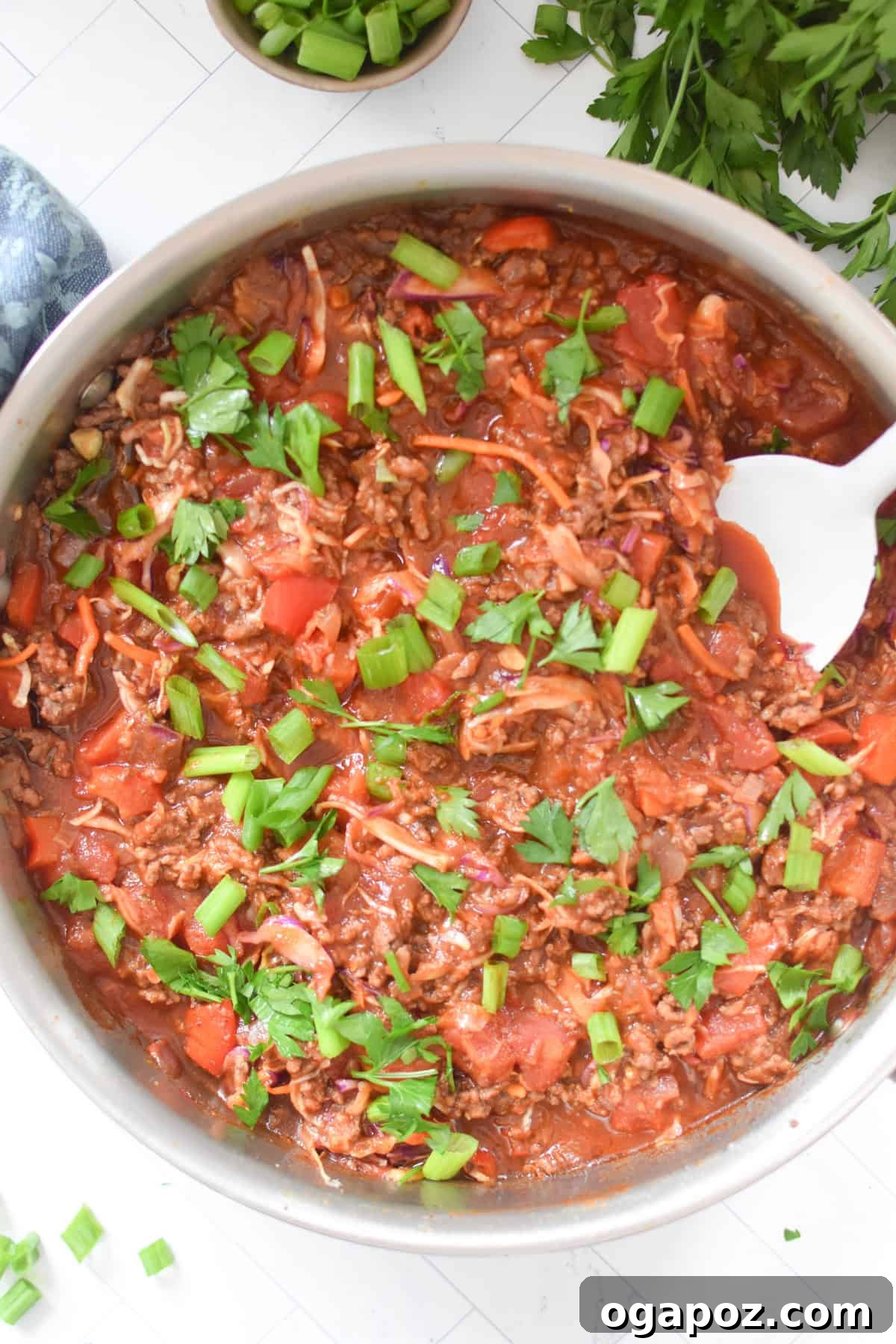 Rustic Mediterranean Beef and Cabbage Stir-fry 7 Mediterranean Beef and Cabbage Stir-fry in a pan with a white serving spoon, highlighting the saucy texture.