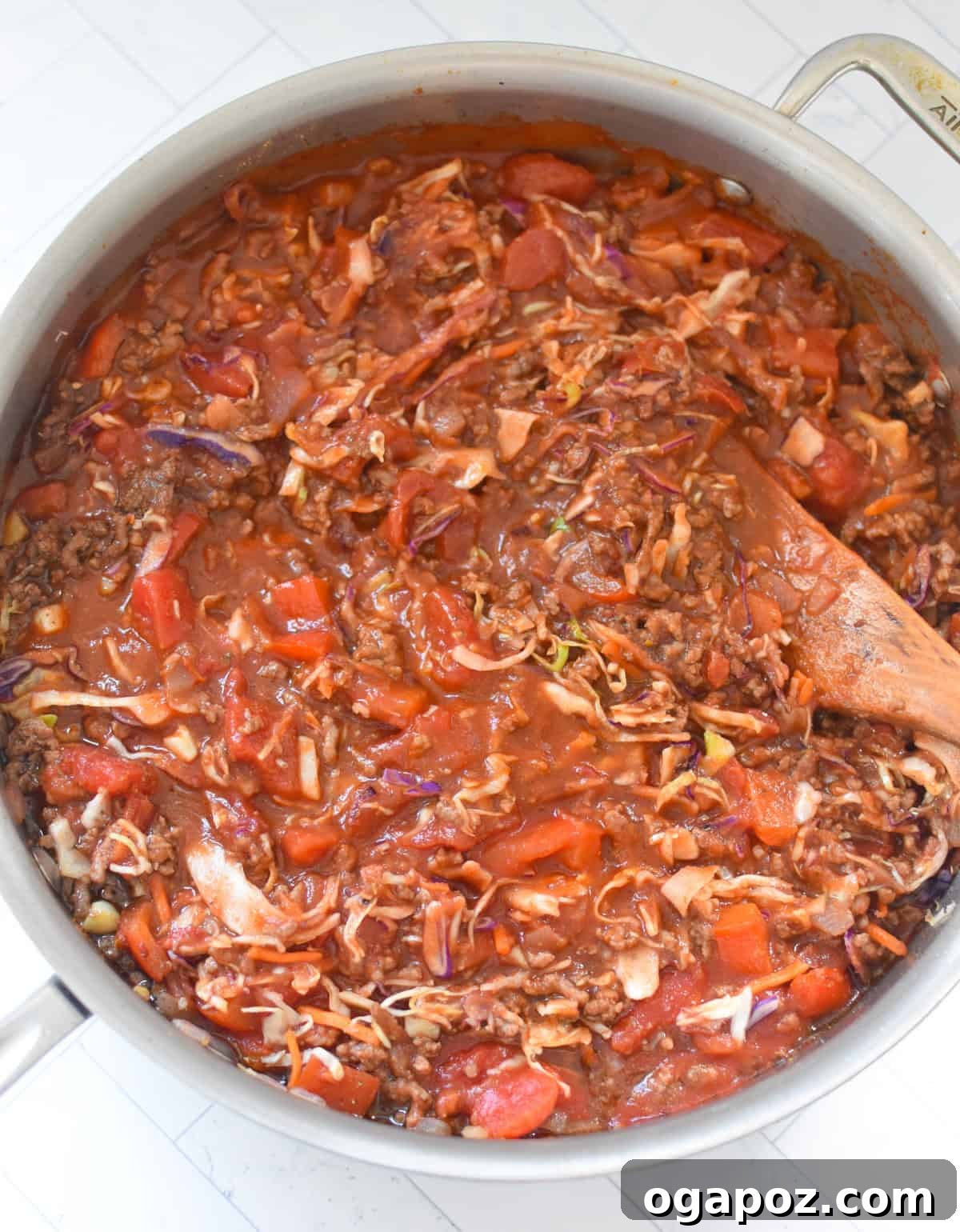 Rustic Mediterranean Beef and Cabbage Stir-fry 10 Adding spices to the Mediterranean Beef and Cabbage Stir-fry in a skillet with a wooden spoon.