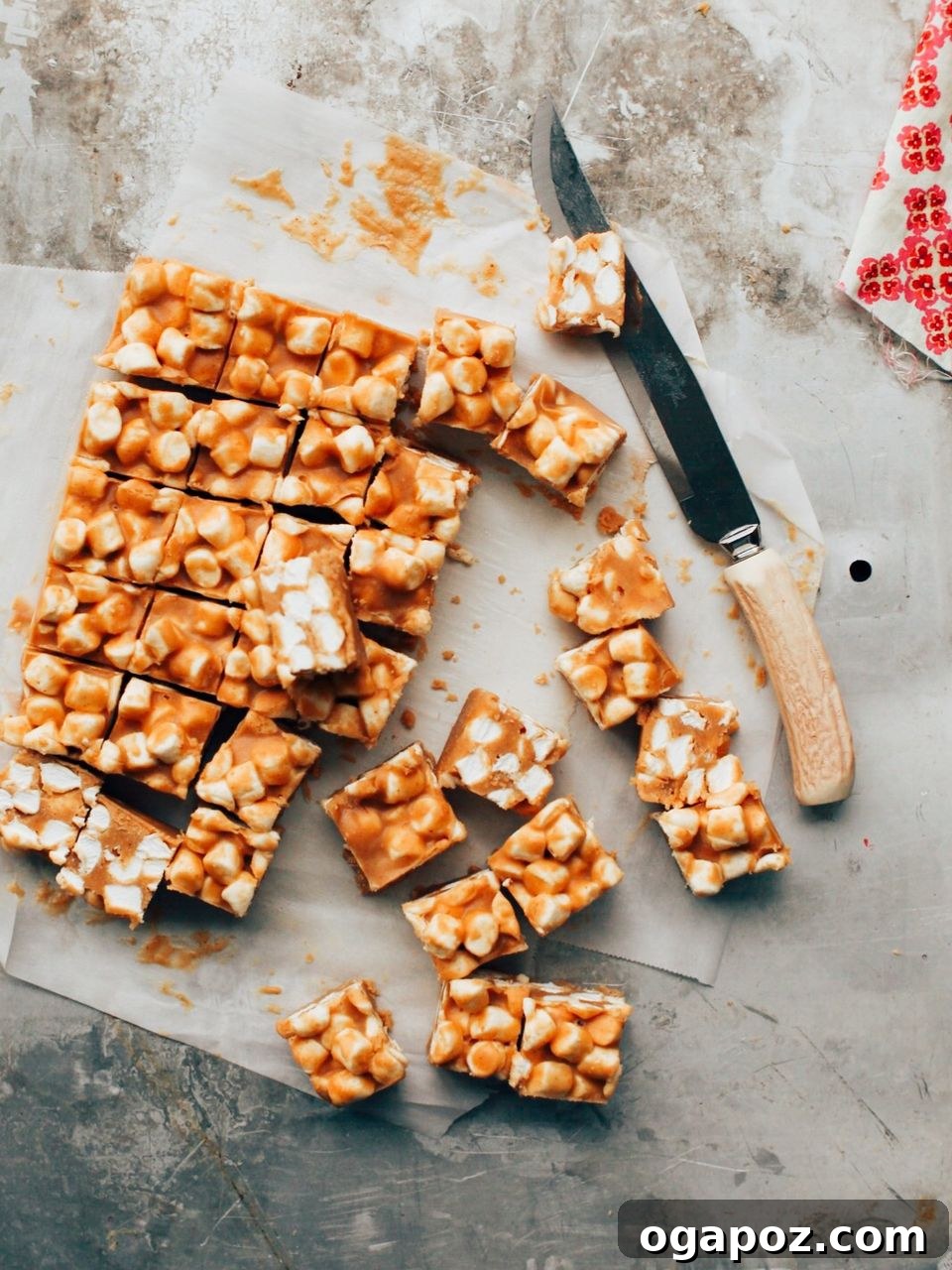 Butterscotch Peanut Butter Confetti Squares 2 Peanut Butter Butterscotch Marshmallow Bars cut into squares, arranged on a sheet of parchment paper.