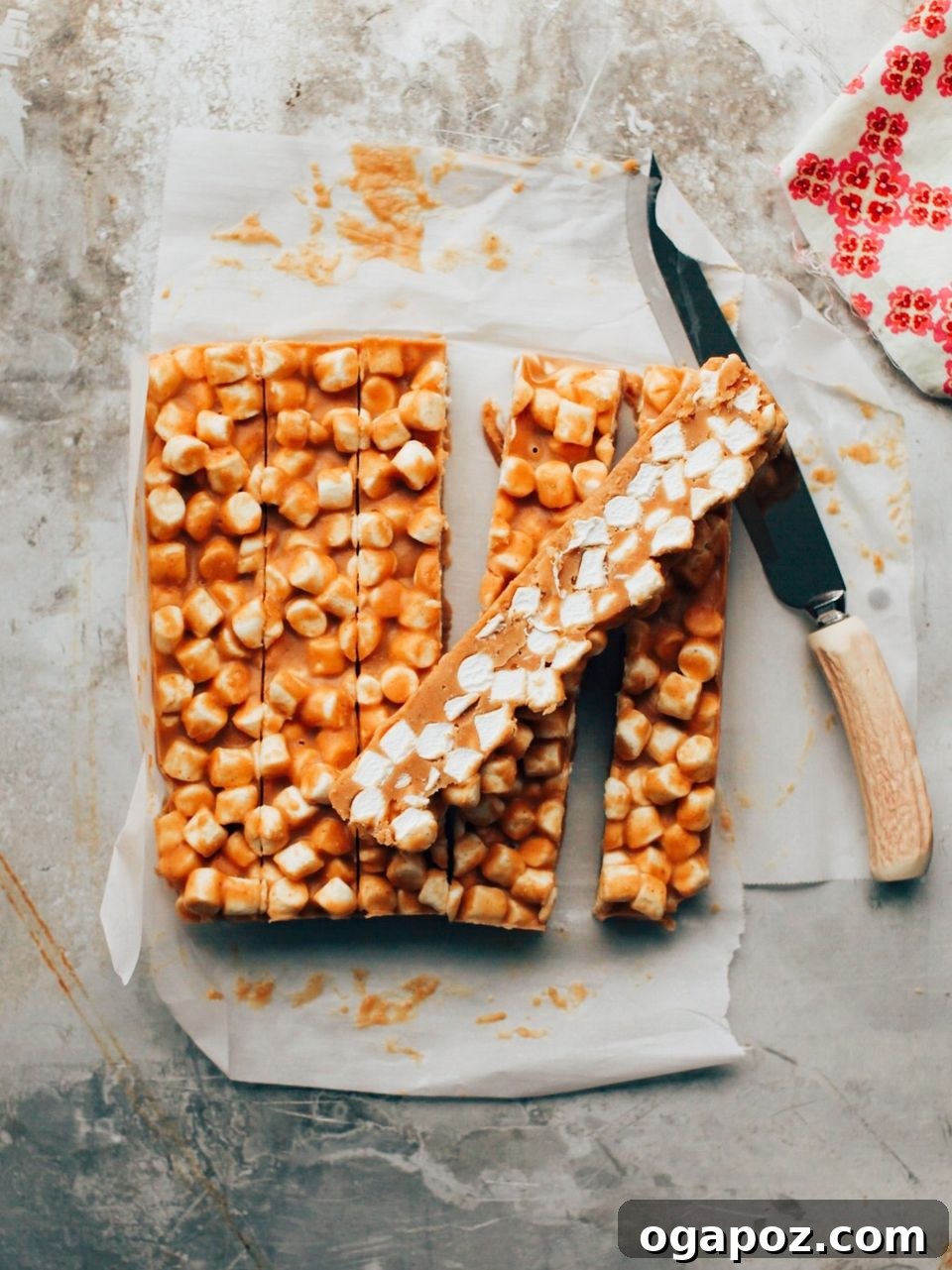 Butterscotch Peanut Butter Confetti Squares 3 Long strips of uncooked peanut butter butterscotch marshmallow mixture in a pan, ready for chilling.