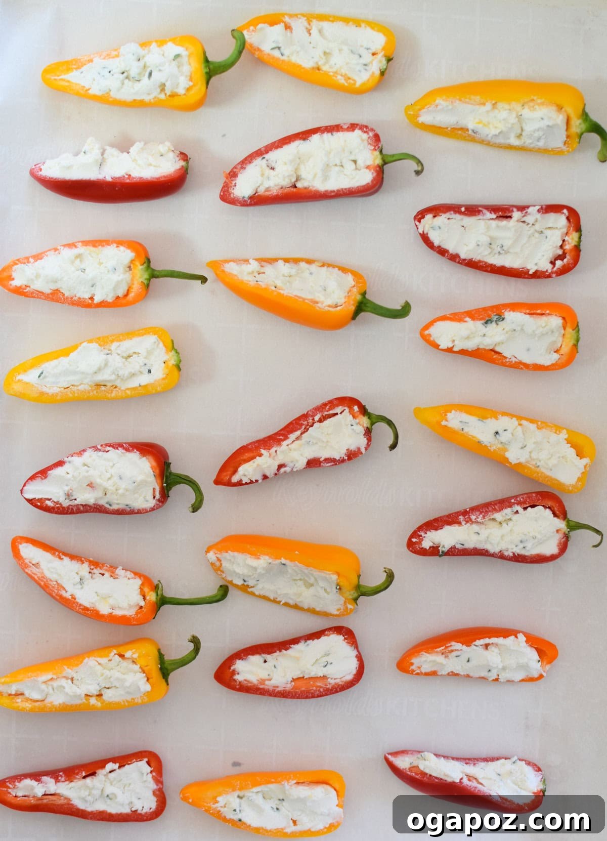Creamy Goat Cheese Stuffed Mini Peppers 11 Goat Cheese Stuffed Mini Peppers arranged on a baking sheet, ready for the oven