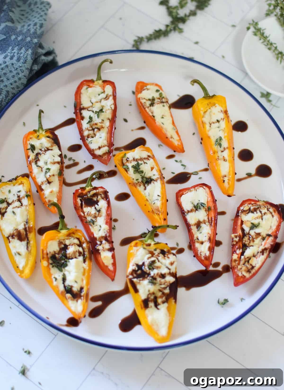 Creamy Goat Cheese Stuffed Mini Peppers 8 Goat Cheese Stuffed Mini Peppers on a white plate with a balsamic glaze drizzle, ready to be served