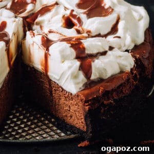 Decadent Chocolate cheesecake with whipped cream and chocolate drizzle, a slice removed.