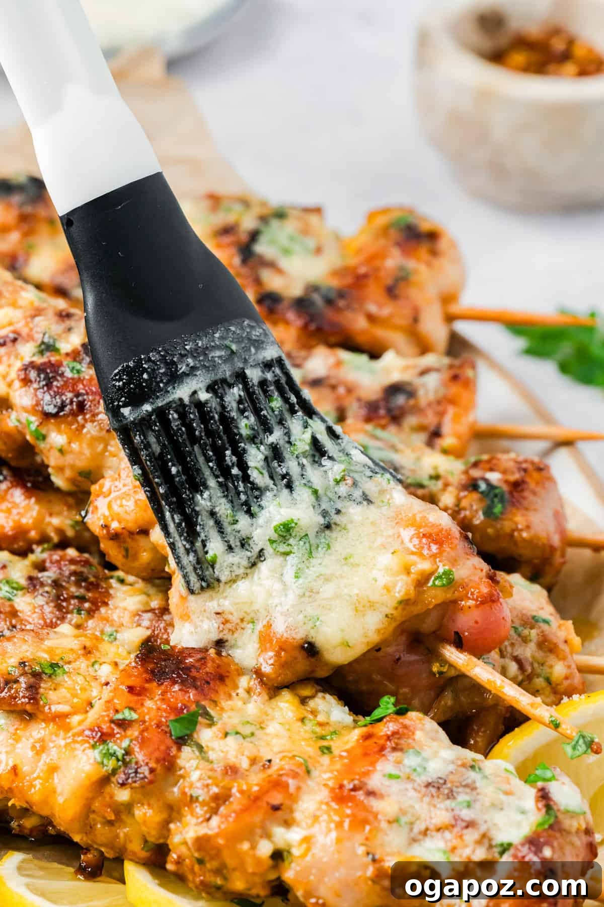 Golden Garlic Parmesan Chicken Skewers 11 Cooked chicken skewers being brushed with garlic butter Parmesan sauce.