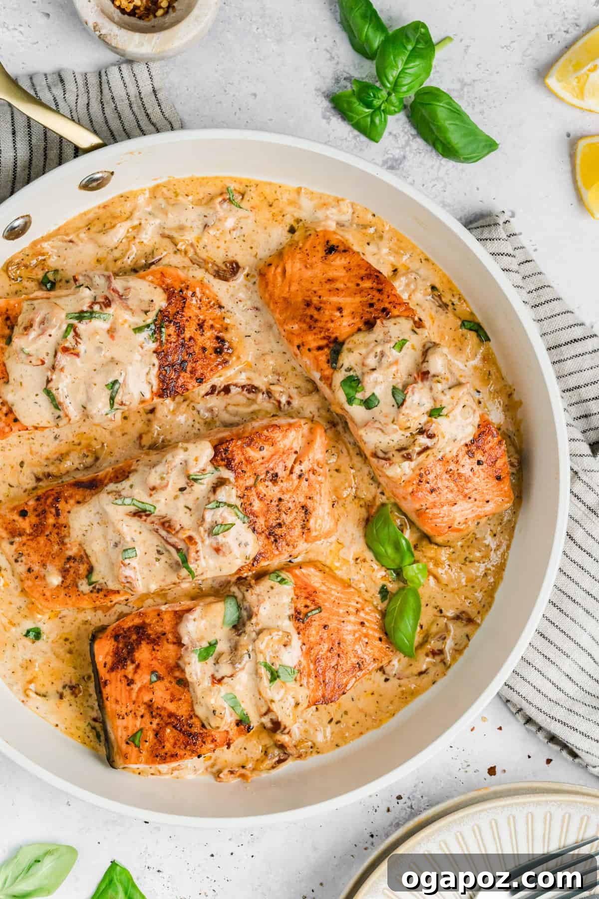 Engagement Salmon 10 Creamy Tuscan Marry Me Salmon in a white skillet, garnished with fresh basil