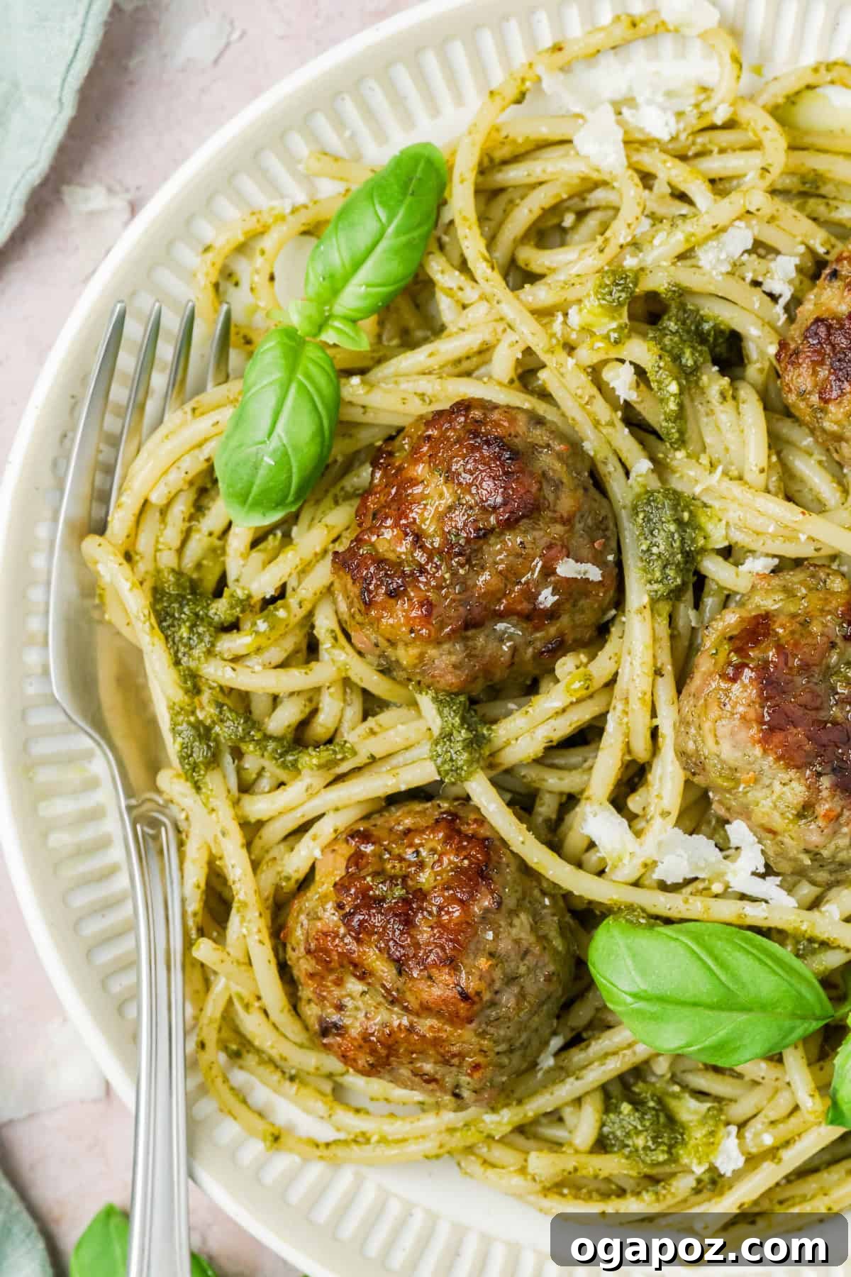 Emerald Pesto Turkey Bites 2 Delicious Turkey Pesto Meatballs served on a white plate with fresh basil garnish, ready to eat.