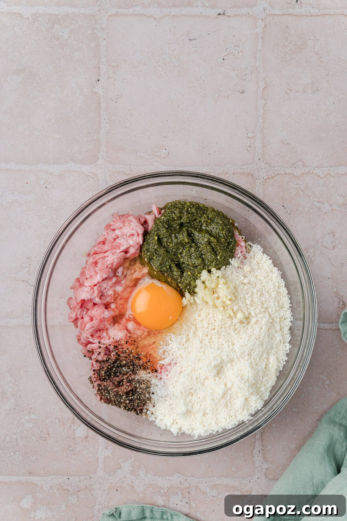 Emerald Pesto Turkey Bites 6 All the Turkey Pesto Meatball ingredients, including ground turkey, pesto, and seasonings, mixed in a glass bowl, ready for rolling.