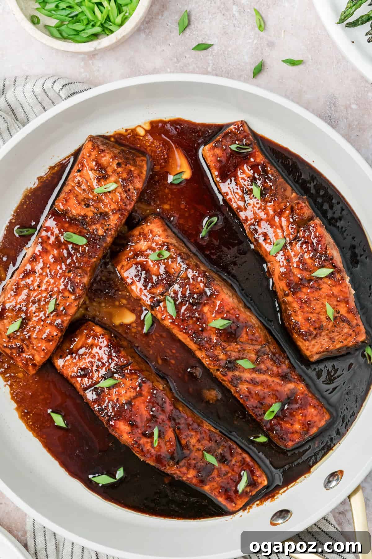 Sticky Bourbon Salmon 12 A close-up shot of Bourbon Glazed Salmon fillets in a skillet, glistening with a rich, caramelized glaze, signifying readiness.