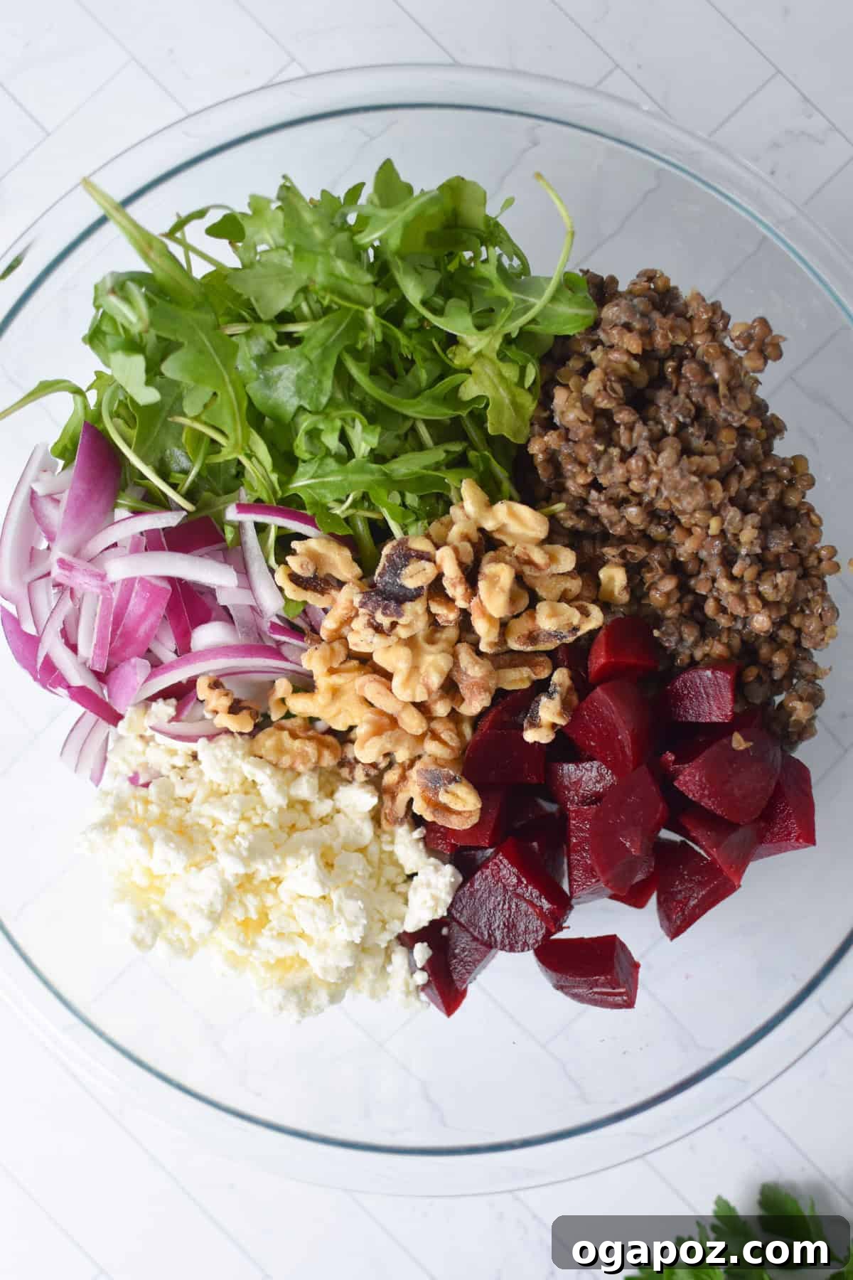 Vibrant Lentil and Beet Salad 8 Lentil Salad ingredients (walnuts, feta, herbs) in a clear mixing bowl, ready for tossing.