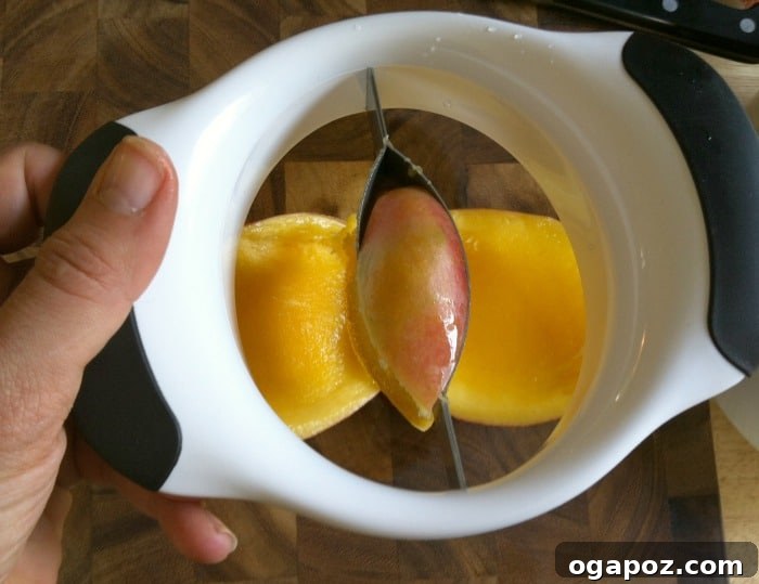 Refreshing Fruit Medley with Zesty Honey-Yogurt Dressing 7 The OXO mango splitter perfectly positioned over a mango, demonstrating how it cleanly separates the fruit from the pit in one swift motion.