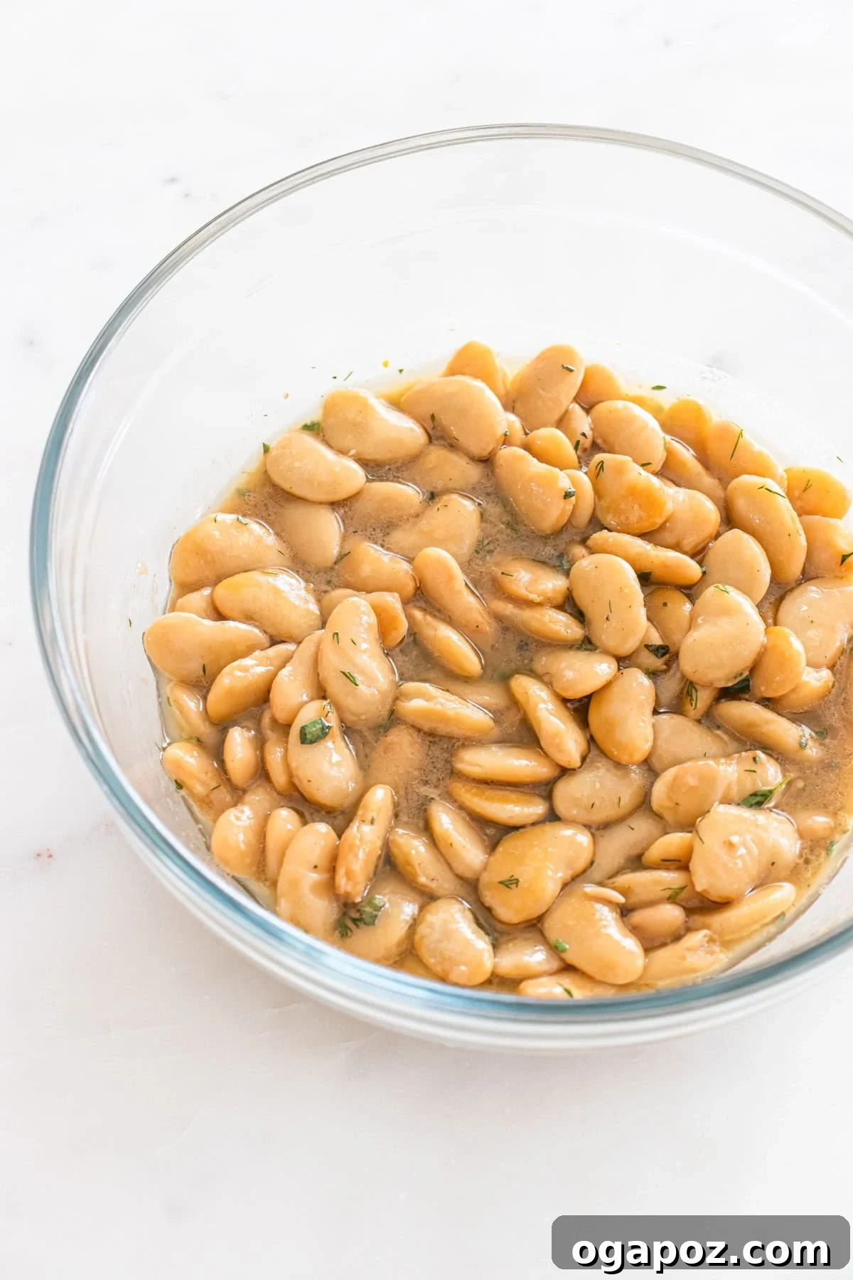 Zesty Greek Butter Bean Salad 8 Butter beans being gently stirred with the dressing