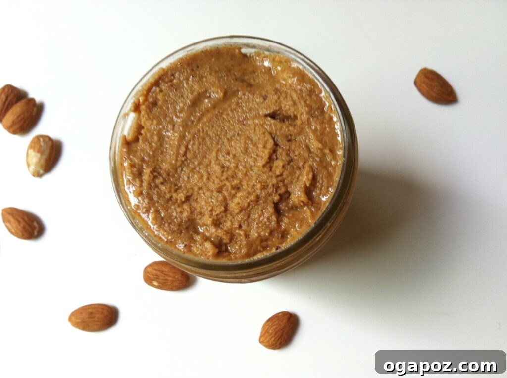 Easy Homemade Almond Butter 2 Jar of freshly made homemade almond butter next to a bowl of almonds