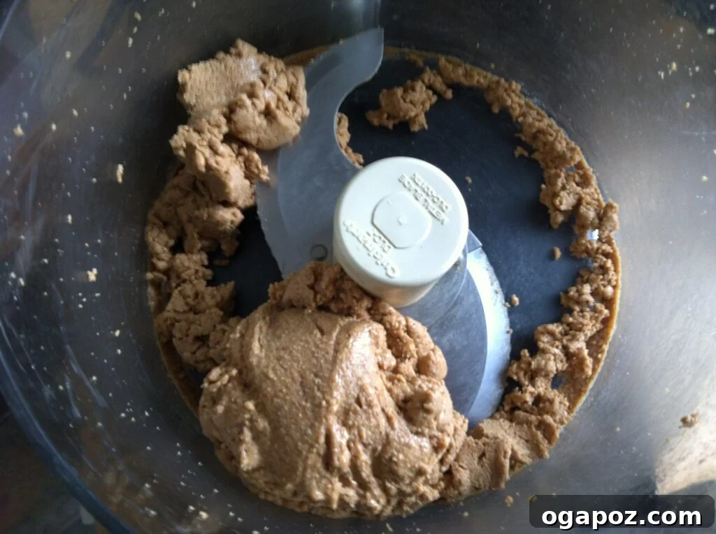 Almonds in food processor have formed a fine, thick paste