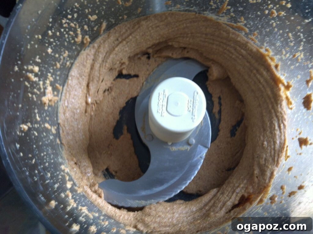 Food processor bowl with almond paste scraped down from the sides