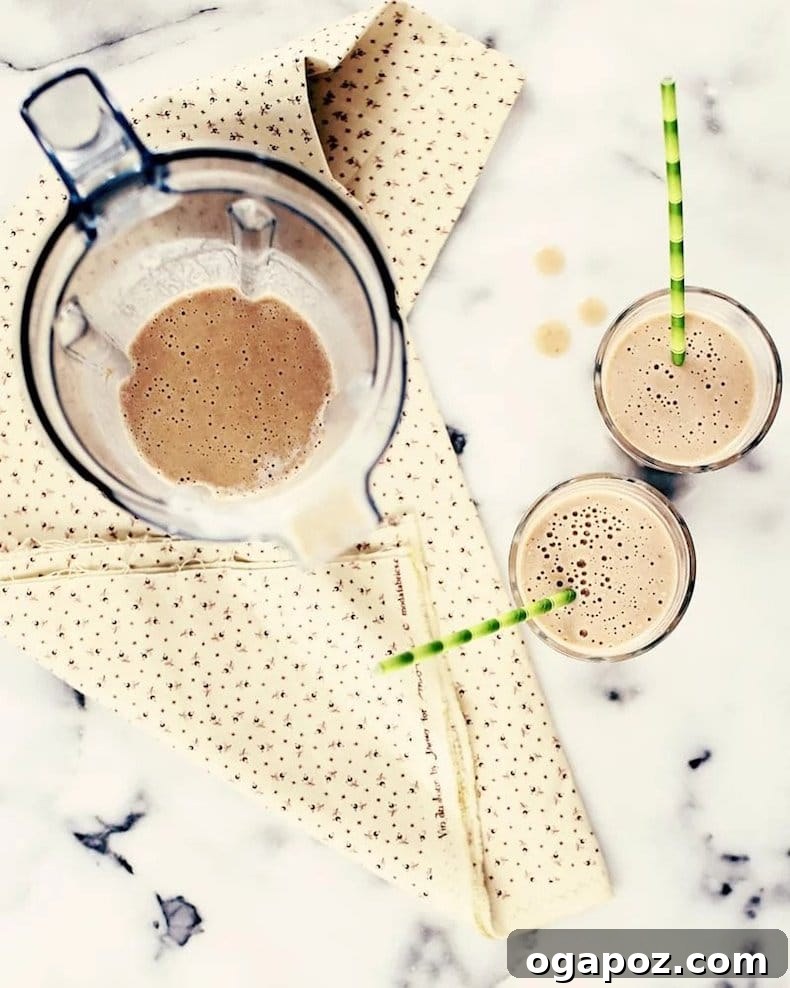Transform Your Health: 25+ Irresistible Smoothie Creations 15 Pumpkin pie smoothie in a glass with green straws and cinnamon stick
