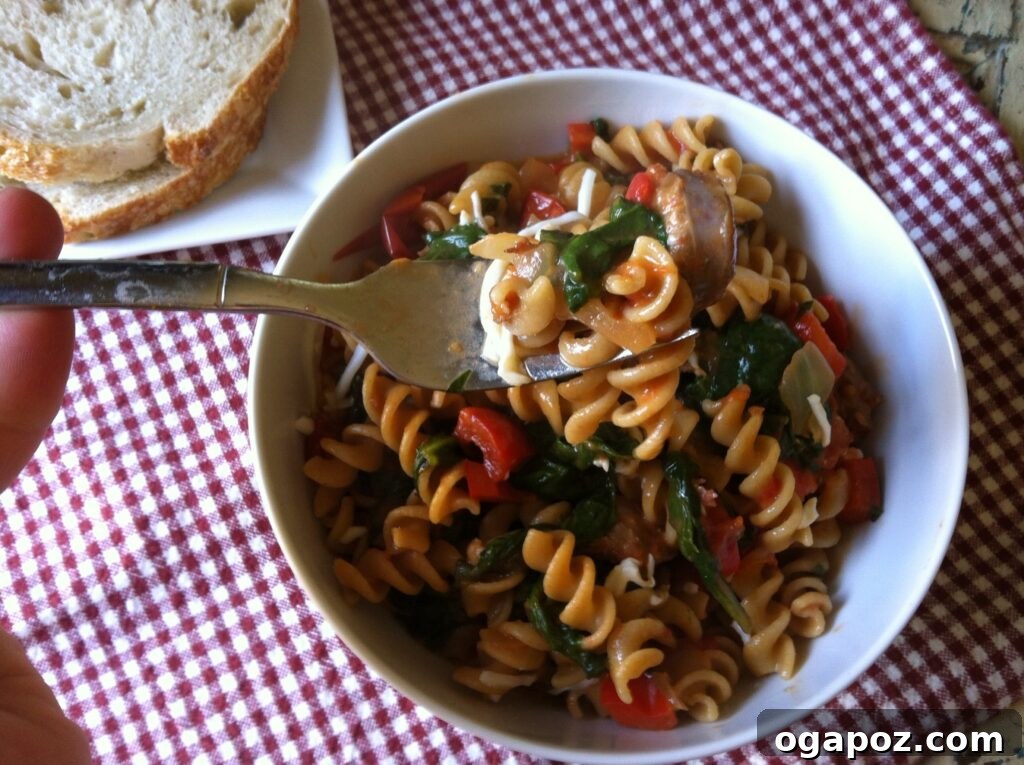 Hearty Skillet Sausage and Spinach Pasta 3 A generous bowl of Skillet Sausage and Spinach Pasta, garnished with fresh herbs and a sprinkle of cheese, invitingly presented.