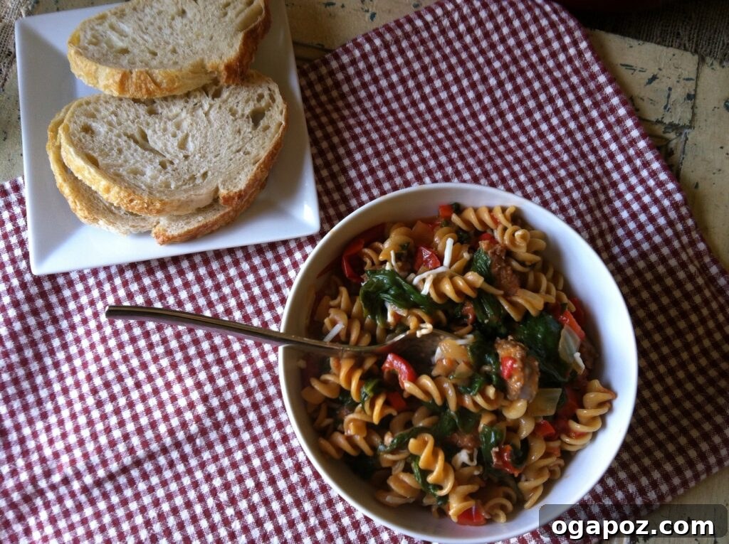 Hearty Skillet Sausage and Spinach Pasta 4 A close-up shot of the Skillet Sausage and Spinach Pasta, showcasing the texture of the pasta, sausage, and vibrant spinach.
