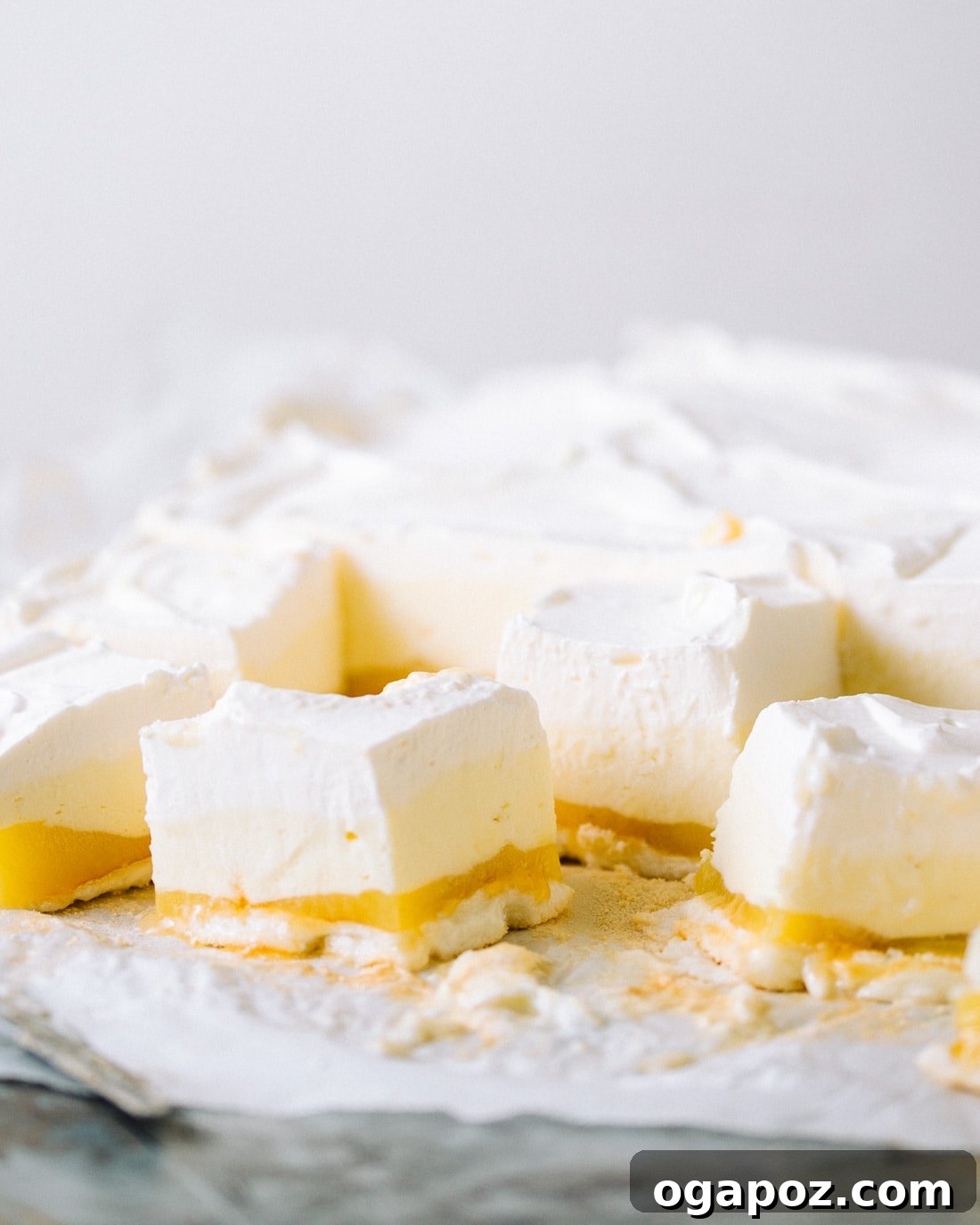 Sunshine Lemon Silk Bars 2 Lemon Mousse Bars with a pristine top layer of whipped cream, sliced neatly