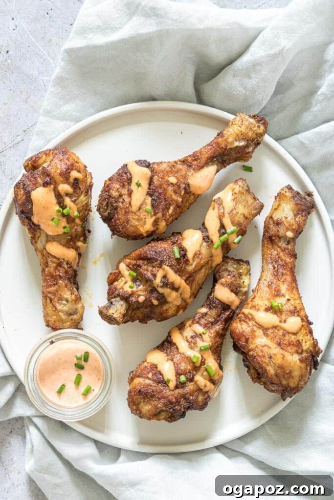 41 Delicious Chicken Drumstick Recipes: Simple and Super Juicy 14 Air Fryer Chicken Drumsticks on a white plate with dipping sauce