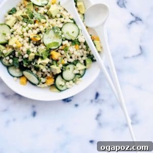 Israeli couscous salad on a plate with spoons