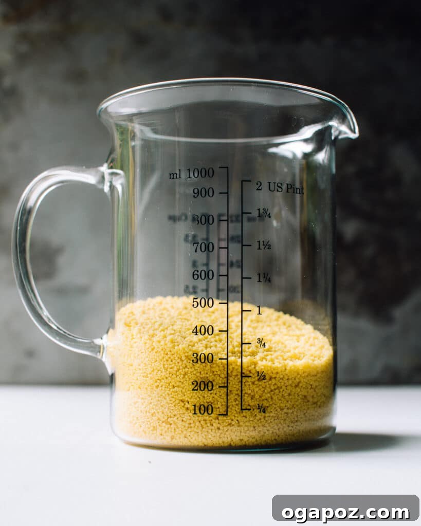 9+ Phenomenal Israeli Couscous Recipes You Must Try 3 Dry Israeli couscous pearls neatly held in a transparent measuring cup, ready for cooking.