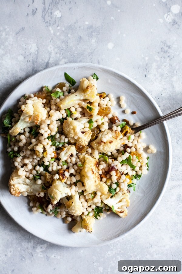 9+ Phenomenal Israeli Couscous Recipes You Must Try 9 A unique Israeli couscous salad featuring roasted cauliflower, crunchy pistachios, and sweet raisins, artfully arranged on a plate.